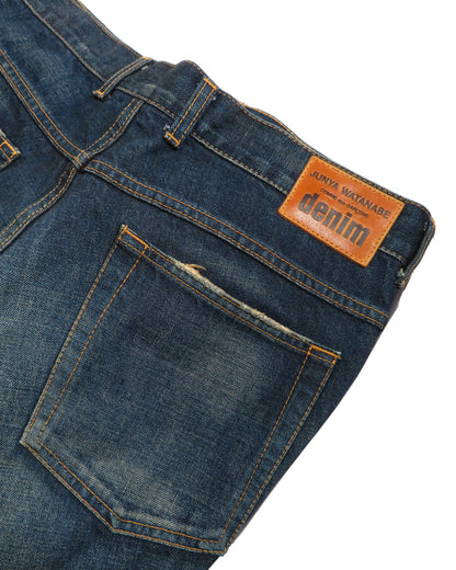 Close-up of blue denim jeans with a brand label on a white background