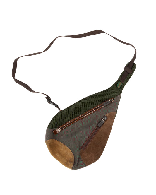 A green khaki canvas and suede sling bag with multiple zippered compartments and brown suede panels, featuring an adjustable strap and a curved ergonomic shape.