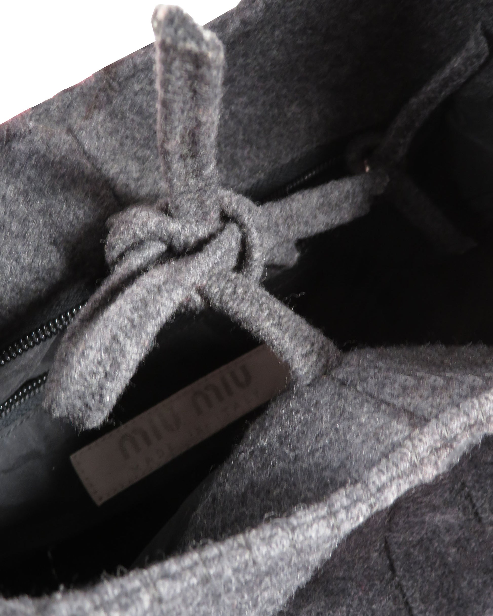 Close-up of a gray textured fabric with a brand label partially visible.