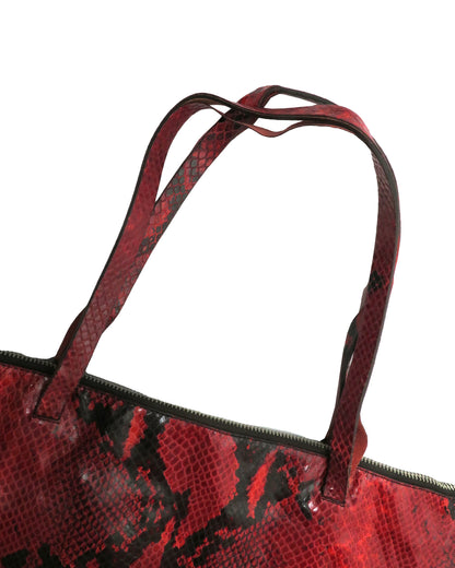 Red and black patterned handbag with a strap on a white background