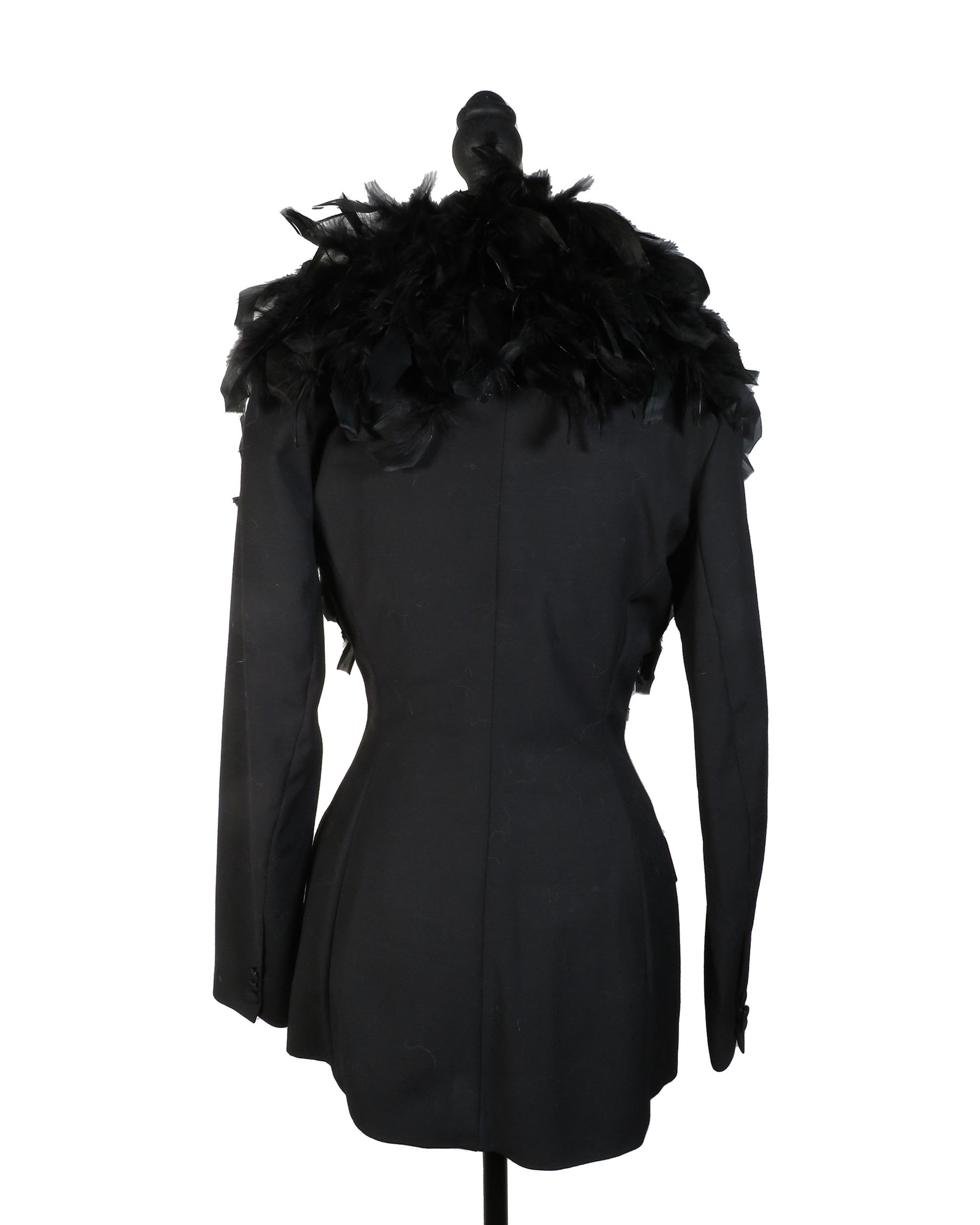 Black coat with feathered shoulders on a mannequin against a white background