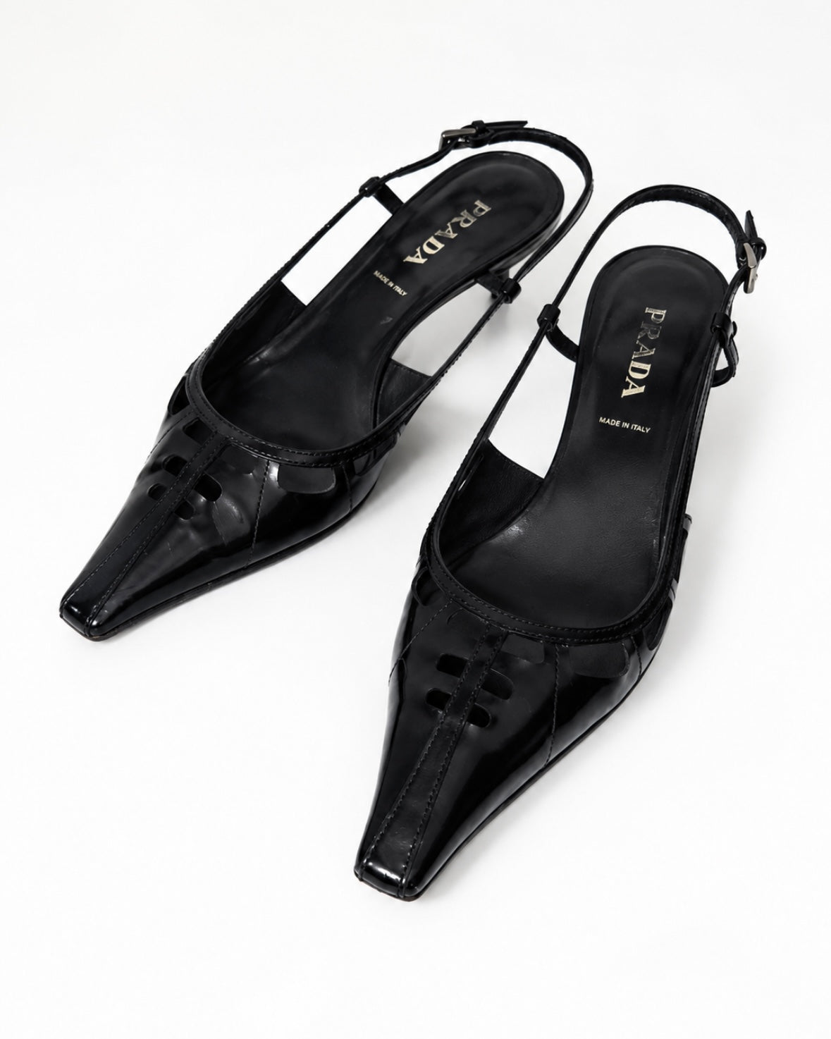 Black pointed-toe slingback heels on a white background