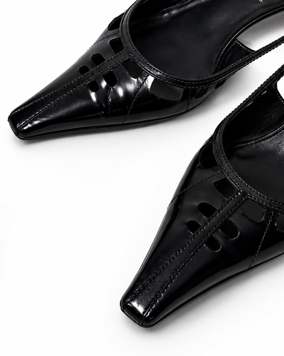 Black high-heeled shoes with cut-out design on a white background