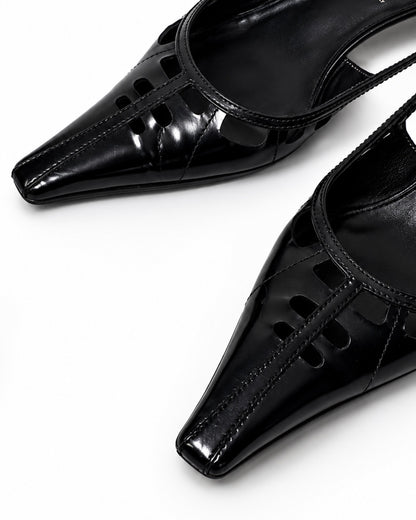 Black high-heeled shoes with cut-out design on a white background