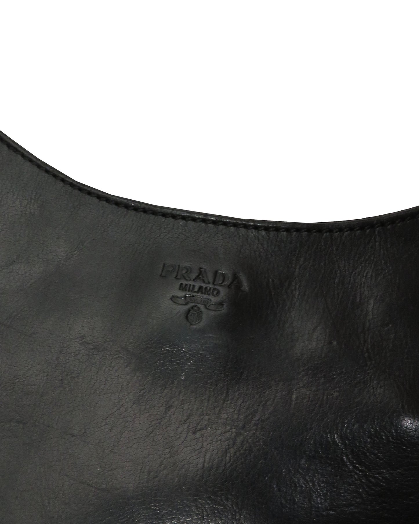 Close-up of a black leather handbag with Prada logo.