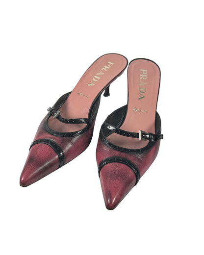 Pair of Prada high-heeled shoes with black straps on a white background