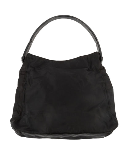 Black nylon shoulder bag with a curved black acrylic handle and embossed 'Prada' detailing.