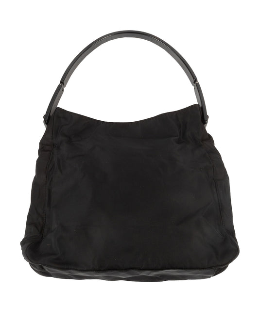 Black nylon shoulder bag with a curved black acrylic handle and embossed 'Prada' detailing.