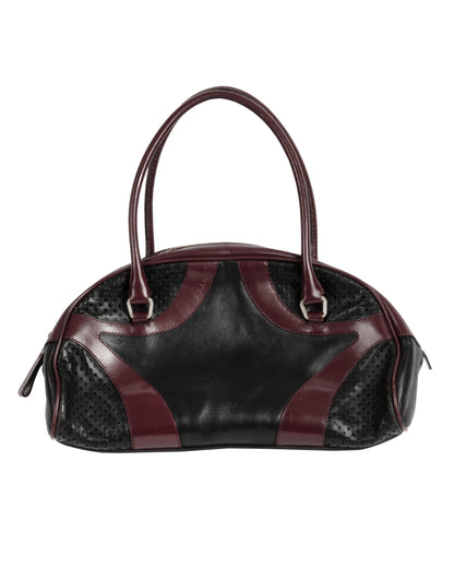 A black and burgundy leather bowling bag with perforated leather paneling and double handles.