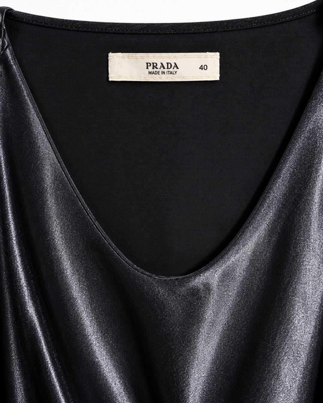 Black satin garment with Prada label on a white background