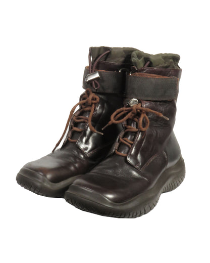 Pair of dark brown leather boots with laces on a white background