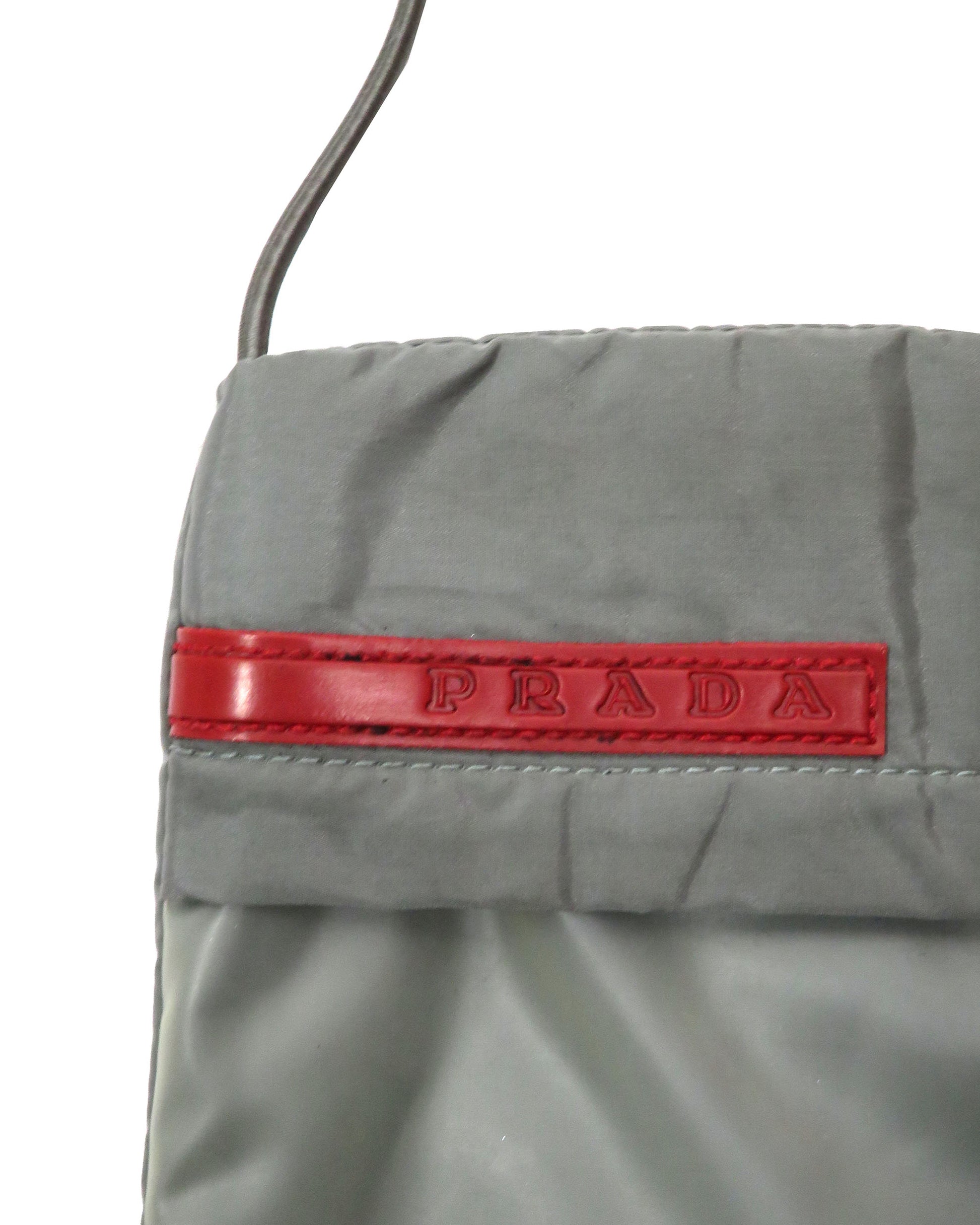 Gray Prada bag with a red logo on a white background