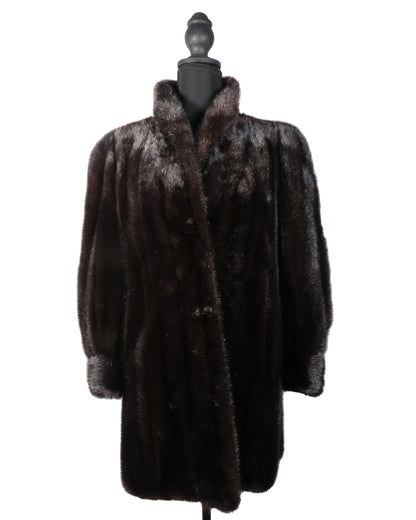 Dark fur coat on a mannequin against a white background