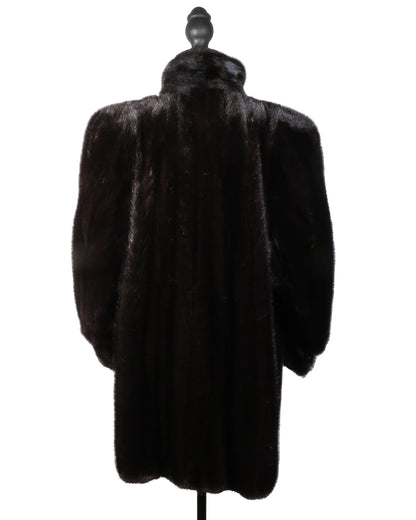 Dark fur coat on a mannequin against a white background