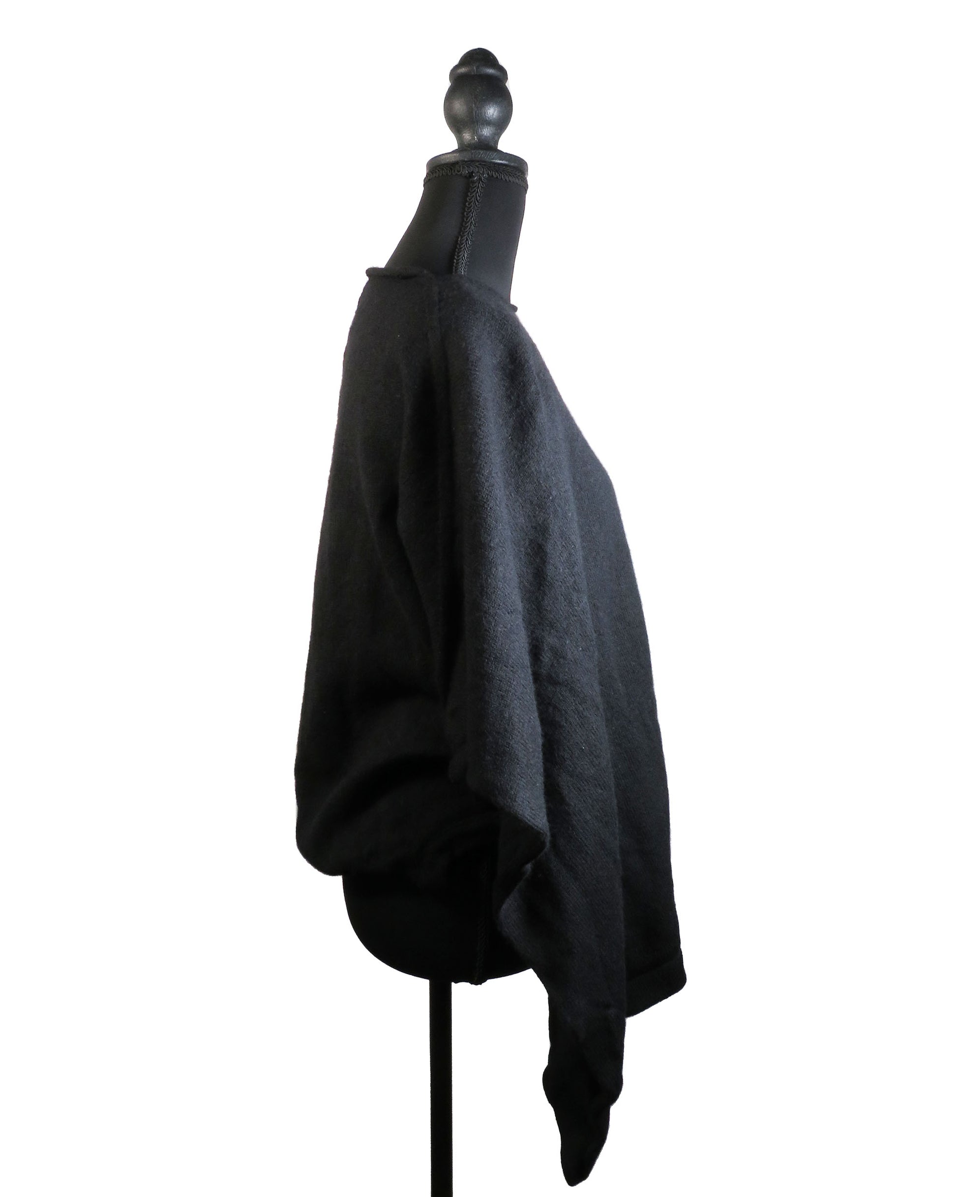 Black poncho on a mannequin against a white background