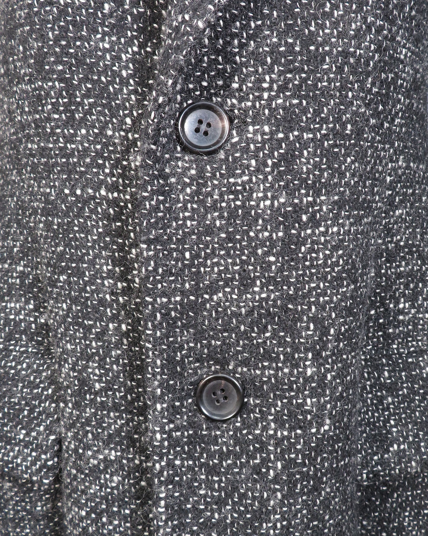 Close-up of a textured gray fabric with two buttons.