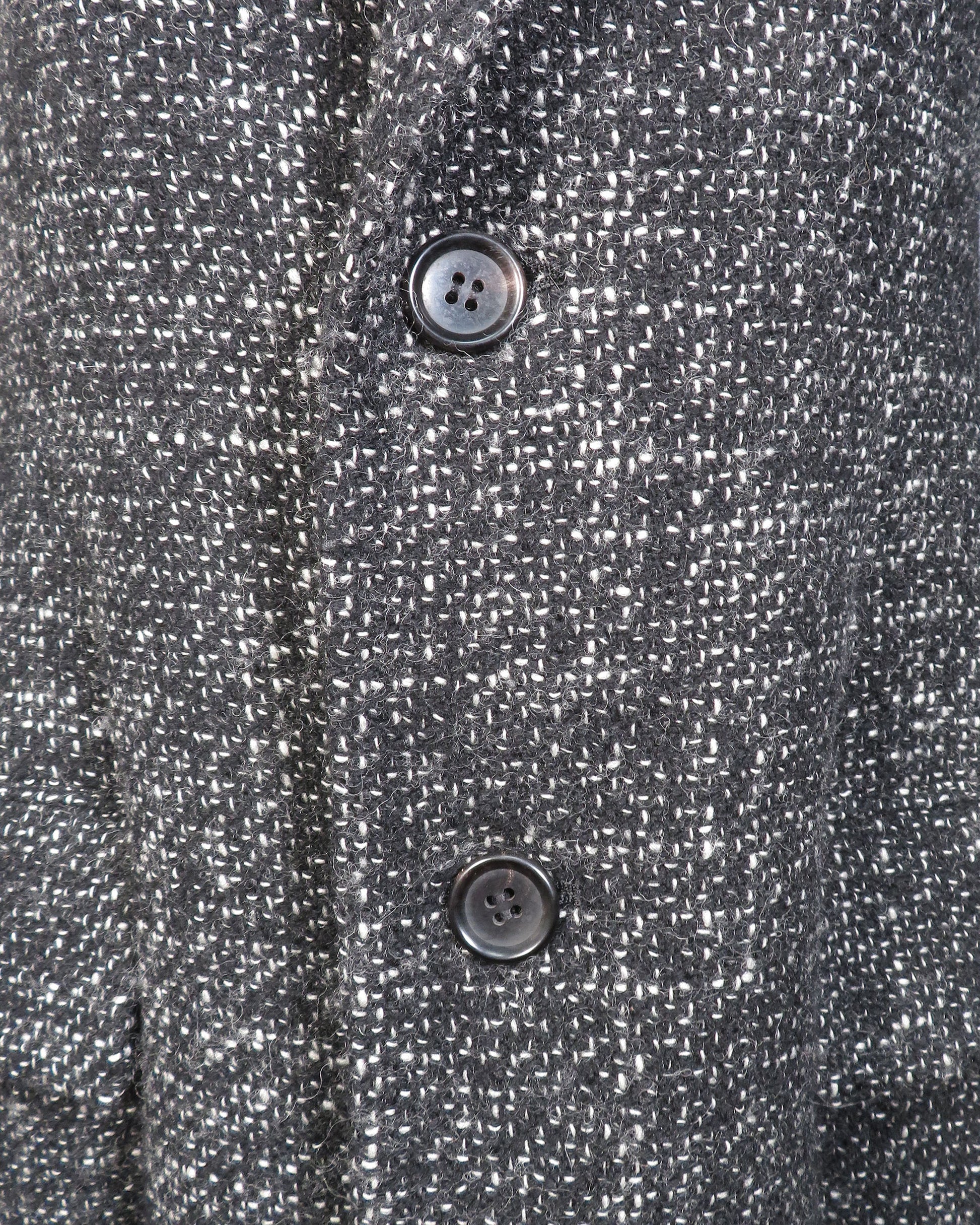 Close-up of a textured gray fabric with two buttons.