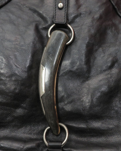 Metal bridle bit on a black leather background