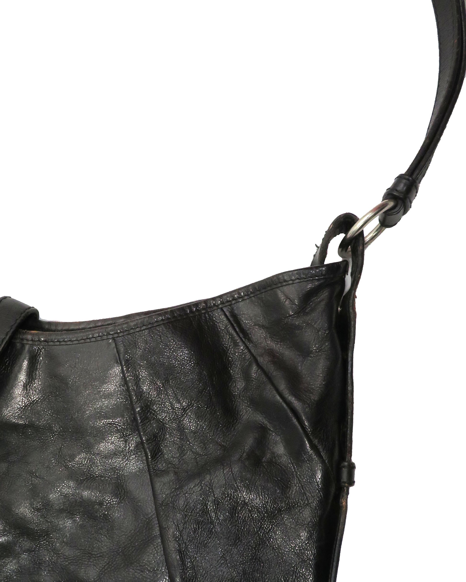 Black leather handbag with a strap on a white background