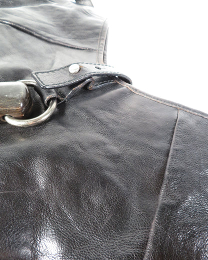 Close-up of a black leather bag with a metal handle.