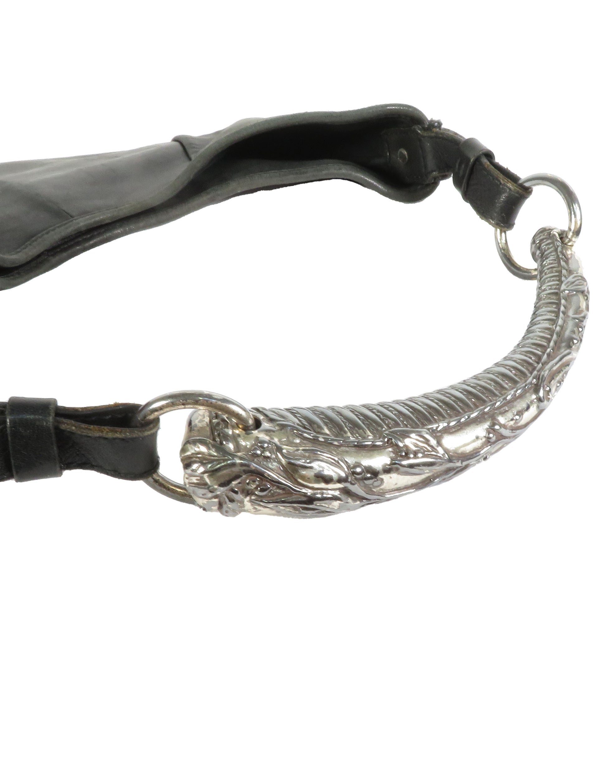Close-up of a black leather strap with a silver decorative ring on a white background