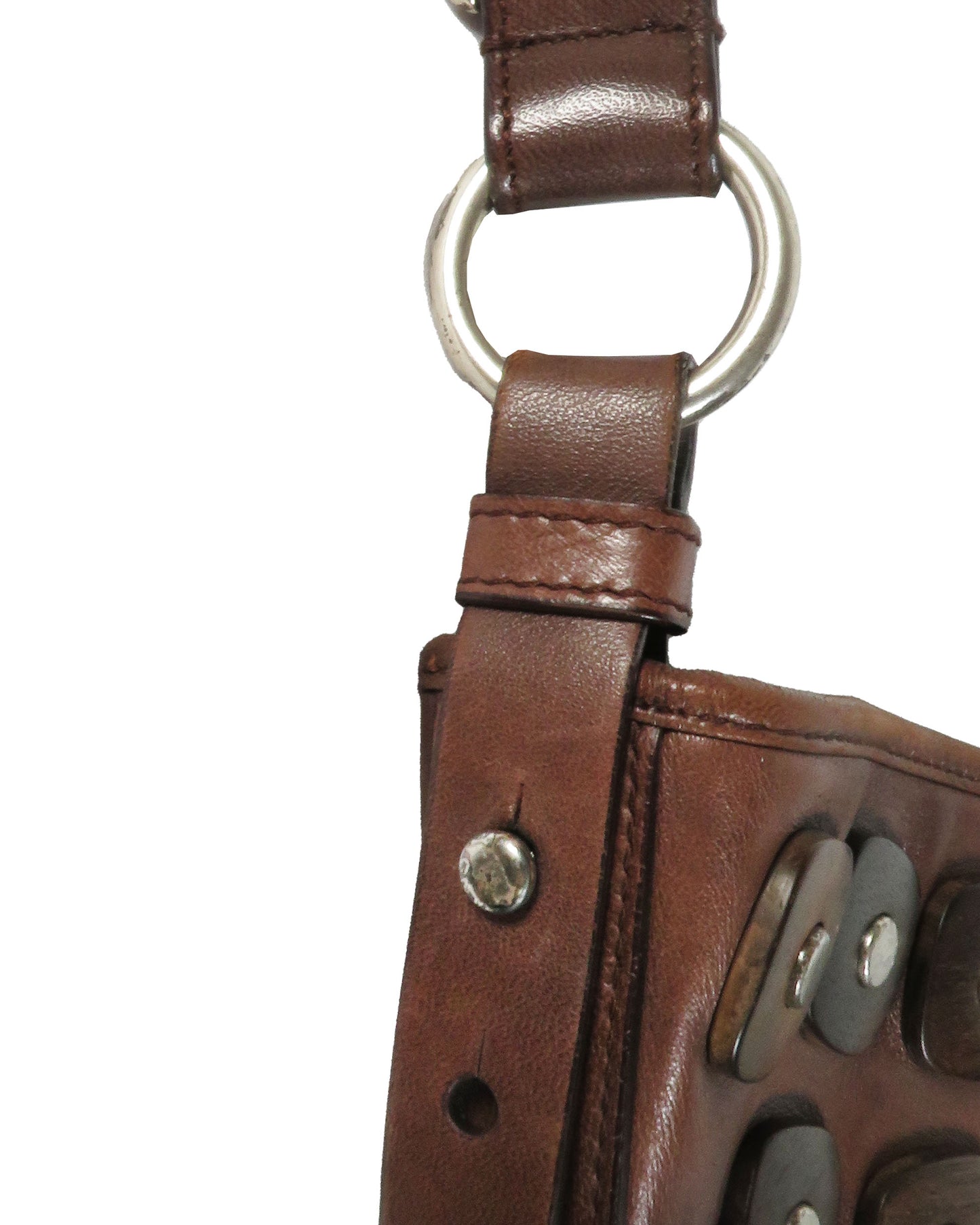 Close-up of a brown leather glove with a metal ring on a white background