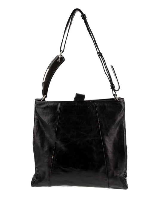 Black leather handbag with a shoulder strap on a white background 