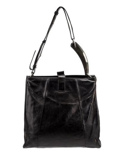 Black leather handbag with a shoulder strap on a white background